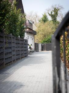 una recinzione di fronte a una casa con balcone di NEU! Forstwald-Haus I Kamin - Netflix - Hot Tub Pool - Düsseldorf a Krefeld