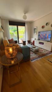 a living room with a couch and a tv at Pombal Bayona in Baiona