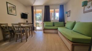 a living room with a green couch and a table at Chez K&D by Antoine in Saint-Raphaël