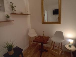 ein Wohnzimmer mit zwei weißen Stühlen und einem Spiegel in der Unterkunft Le Marais,center ,5 minute Eiffel tour and Louvre meusm ,1 mins metro in Paris