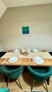 una mesa de madera con sillas y platos. en Emerald dream house, en Swindon 13 fotos más