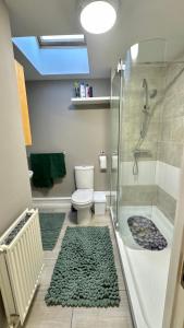 y baño con ducha, aseo y ducha acristalada. en Emerald dream house, en Swindon