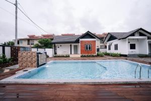 a swimming pool in the backyard of a house at Sutera Damai Heritage in Kota Bharu