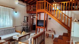 a living room with a staircase and a couch and a television at Christina house in Sykia Chalkidikis