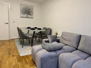 a living room with a couch and a table with chairs at Park Villa, Stevenage in Shephall