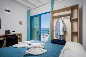 a bedroom with a blue bed with towels on it at Finikas Resort Sfakia - Seaside Rooms in Loutro