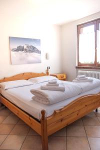a bedroom with a large wooden bed with white sheets at Hotel ristorante San Marco 
