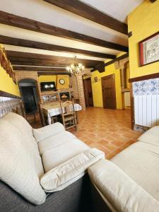 ein Wohnzimmer mit Couch und ein Esszimmer in der Unterkunft Casa Rural Calderón de Medina l, ll y lll in Siete Iglesias de Trabancos