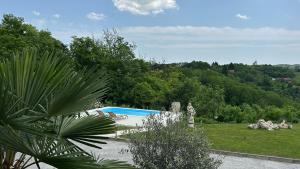 a swimming pool in a garden with trees in the background at Apartman Perla in Gornji Kraj