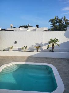 a swimming pool in front of a white wall at La Lapa in Arrecife