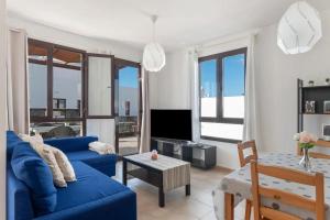 Una sala de estar con un sofá azul y una mesa. en Luxury Villa Lanzarote, en Playa Blanca