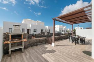 Un patio con parrilla y mesa y sillas. en Luxury Villa Lanzarote, en Playa Blanca
