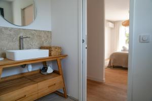 une salle de bain avec un lavabo et un miroir dans l'établissement Bergerie entre plage et maquis, à Zonza