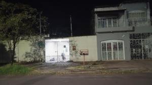 ein weißes Gebäude mit einem Tor davor in der Unterkunft Casa quase frente a Rodoviária in Corumbá