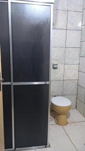 ein Bad mit einem WC und einer schwarzen Duschkabine in der Unterkunft Casa quase frente a Rodoviária in Corumbá + 23 Fotos