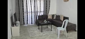 a living room with a couch and a table at AylinAylan in Ḩawmat al Badawīyīn