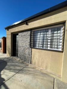 a building with a garage with a large window at Departamento Boulevard in Malargüe