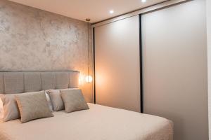 a bedroom with a large bed with white sheets and pillows at Apartments Kostic- Sea view in Tivat