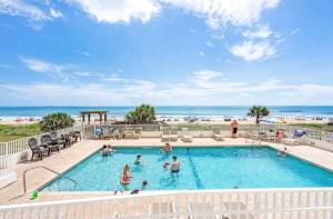 a pool with people in it with the ocean in the background at Quiet direct oceanfront 2 bed 2 bath condo w/pool in Ormond Beach