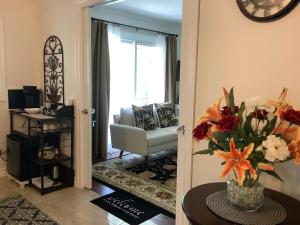 a living room with a chair and a vase of flowers at Via Veneto - Old Town in Niagara on the Lake