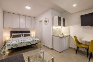 a bedroom with a bed and a kitchen with a sink at Studio Apartment Nikol in Split
