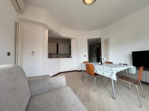 a living room with a table and a couch at WELCOME RIVIERA Primavera 1A Vista mare- spazioso e comodo appartamento-2 bagni-wifi-aria condizionata in ogni stanza-garage a pagamento 15 euro al giorno in Rapallo