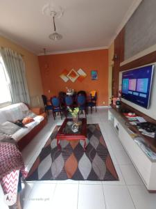 a living room with a couch and a tv at Casa Bromélia in Ricardo de Albuquerque