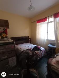 a bedroom with a bed and a chair and a window at Casa Bromélia in Ricardo de Albuquerque