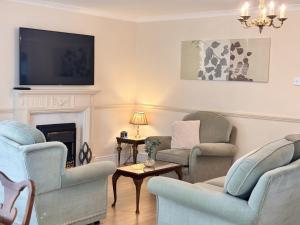 a living room with two chairs and a fireplace at Spacious Home for Workers & Families - Quiet area in Newton Aycliffe