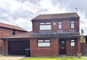 a red brick house with a black door at Spacious Home for Workers & Families - Quiet area in Newton Aycliffe