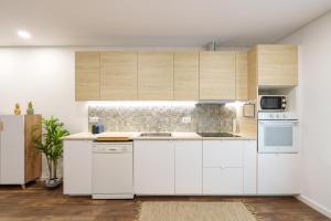 a kitchen with white cabinets and white appliances at VIVA Spacious Apartment Campanhã in Porto