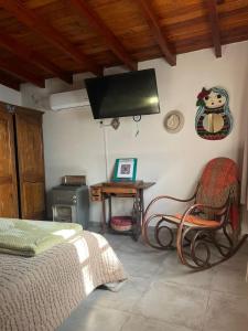 a bedroom with a bed and a desk and a television at Lunas de Spilimbergo in Cordoba