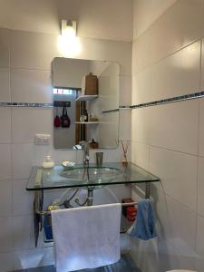 a bathroom with a glass sink and a mirror at Lunas de Spilimbergo in Cordoba +8 photos