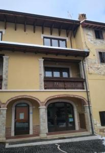 a yellow building with windows and a balcony at La tana delle Byrbe in Ovindoli