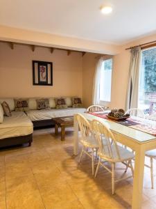 a living room with a couch and a table and chairs at Casa Llao alojamiento de montaña in San Carlos de Bariloche