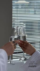 a woman holding a wine glass in front of a window at Apandnrosm in Vlorë