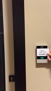 a person holding a piece of paper on a door at Apandnrosm in Vlorë