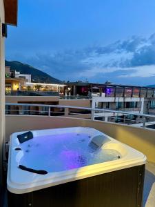 a hot tub on the balcony of a building at Apandnrosm in Vlorë
