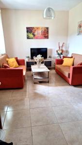 een woonkamer met twee banken en een tv bij Lemon tree House in Skala Marion +17 foto's