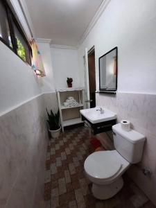 a bathroom with a white toilet and a sink at Sanset Villa in Alburquerque +23 photos
