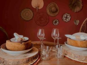 a table with wine glasses and bowls and plates on it at Ô cinq sens in Mortagne-du-Nord