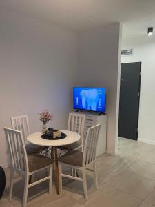 a table and chairs with a television in a room at Apartament 4 Wolności in Brzeg +1 photo
