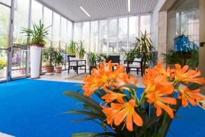 a lobby with orange flowers and a blue floor at Hotel Majorca in Cesenatico