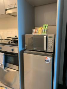 a microwave on top of a refrigerator in a kitchen at Imperial Garden1 in Auckland