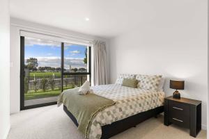 a bedroom with a bed and a large window at Memorial View - Tauranga Holiday Home in Tauranga