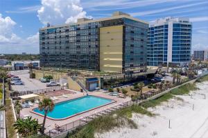 Un complejo con piscina y un edificio. en First floor direct beach access, en Daytona Beach