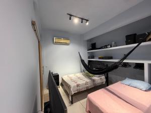 a room with two beds and a hammock in it at Suíte com Copa e Sala de Reunião in Santarém