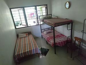 a room with two bunk beds and a window at Private Guest Room 3 Bunks & Bath Rathanapitiya in Boralesgamuwa +6 photos