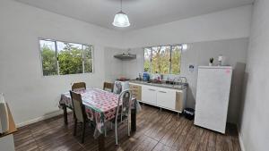 a kitchen with a table and a refrigerator in it at Casa em Cotia Tranquila e Familiar Thermas Animalia Park CT SP in Cotia