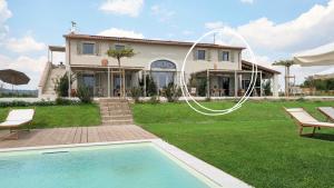 a house with a swimming pool in front of a yard at Podere del Bagnolino - Appartamento Belvedere in Santa Luce